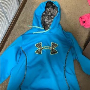 A neon blue under armour hoodie with a camo inside